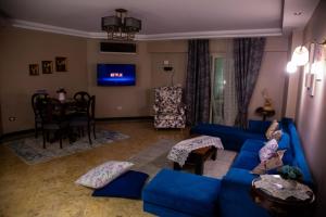 a living room with a blue couch and a table at A Family Friendly Apartment in Cairo