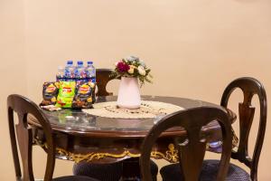 einen Tisch mit einer Vase aus Blumen und Getränken darauf in der Unterkunft A Family Friendly Apartment in Kairo