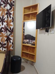 ein Wohnzimmer mit einem TV und einem Spiegel in der Unterkunft Maison d'hôte Najah in Khenifra