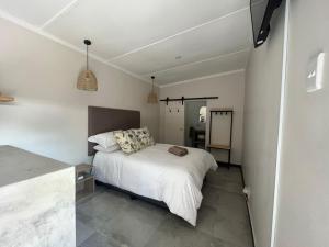 1 dormitorio con 1 cama blanca y cocina en KNUS selfsorg, en Bethlehem