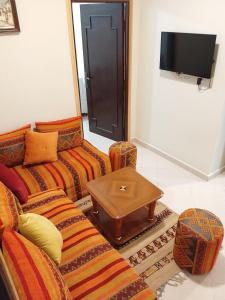 a living room with two couches and a coffee table at Maison d'hôte Najah in Khenifra