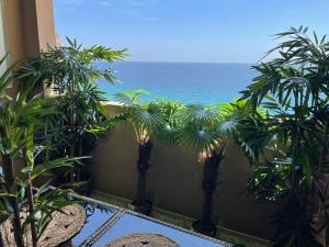 un balcone con palme e vista sull'oceano. di BY NEPTUNE - la Palme Riviera Beach and Pool view a Cannes