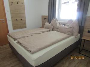 クライナルにあるAppartement Heissのベッド(白いシーツ、枕付)
