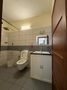 a bathroom with a toilet and a sink at Aambal Residency in Cochin