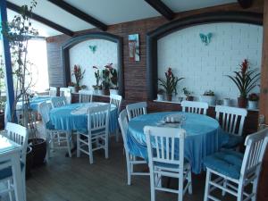 un restaurante con mesas azules y sillas blancas en Mavi Inci Park Otel en Erdek