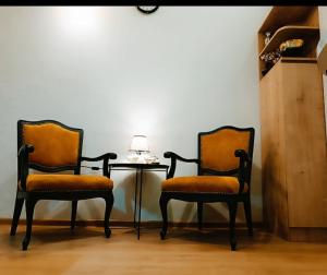 deux chaises assises à côté d'une table avec une lampe dans l'établissement New apartment BARNABA close to Holiday Inn, à Tbilissi