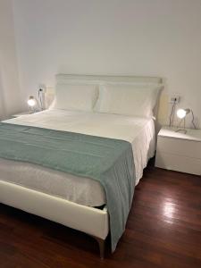 um quarto com uma grande cama branca e 2 candeeiros em EXE NAPOLI STADIUM APARTMENT em Nápoles