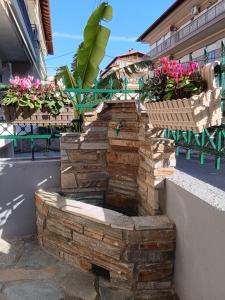 a stone fire pit with flowers in baskets at Stone House - Bike Friendly Home in Edessa