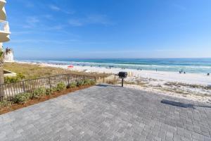 a walkway to the beach with people in the ocean at Wait'n on Sundown in Destin