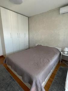 a bedroom with a bed and white cabinets at MANHATTAN APARTMAN Belvil in Belgrade