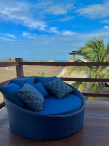 a blue couch on a deck with a view of the beach at Pousada Lá em Casa in Barra Grande