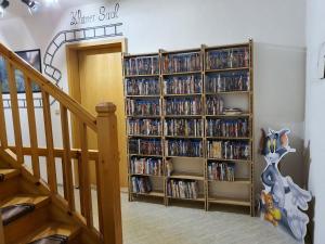 a book shelf filled with dvds next to a staircase at Kleiner Saal in Kurort Oberwiesenthal