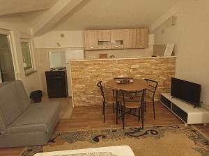 sala de estar con mesa y cocina en Apartments Aldi, en Mostar
