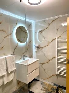 a bathroom with a sink and a mirror at Pensiunea Adrian in Novaci-Străini