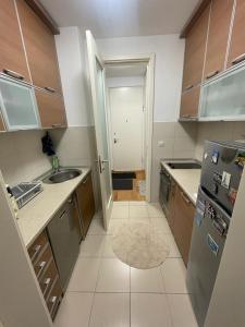 a small kitchen with a sink and a refrigerator at MANHATTAN APARTMAN Belvil in Belgrade