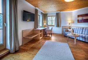 a living room with a couch and a table at Hotel Häuserl im Wald in Mariapfarr