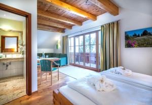 a hotel room with a bed and a bathroom at Hotel Häuserl im Wald in Mariapfarr