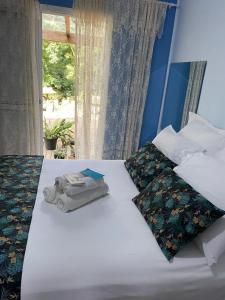 uma cama com duas toalhas com uma janela em Pousada Wit em Palmeira