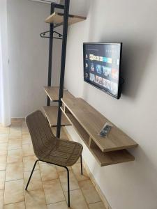 a chair sitting in front of a tv in a room at Minimal House in Paralia Katerinis