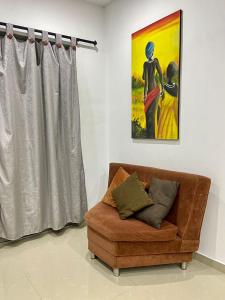 sala de estar con sofá y pintura en Acogedor Apartamento Cercano al Aeropuerto Ernesto Cortissoz en Malambo