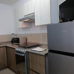 a kitchen with a stove and a microwave at Departamento Los Héroes Veracruz in Veracruz