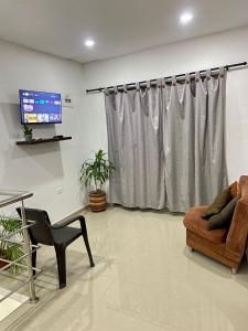 a living room with a couch and a tv at Acogedor Apartamento Cercano al Aeropuerto Ernesto Cortissoz in Malambo