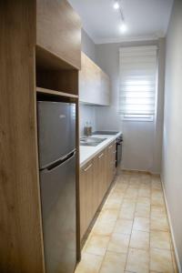 a small kitchen with a refrigerator and a sink at Minimal House in Paralia Katerinis