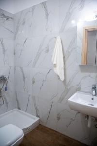 a white bathroom with a sink and a toilet at Minimal House in Paralia Katerinis