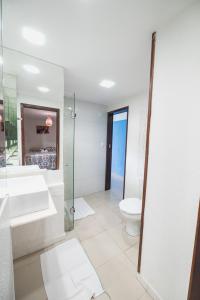 a bathroom with a toilet and a sink and a shower at Apartamentos Natal Ponta Negra Vista Espetacular para o Mar in Natal