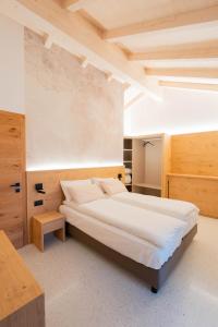 1 dormitorio con 1 cama grande y paredes de madera en Agriturismo Val Castel, en Sporminore