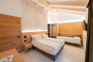 a small room with two beds and a desk at Agriturismo Val Castel in Sporminore