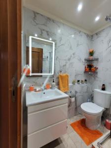 a bathroom with a white sink and a toilet at Cosy Dounia avec parking privatif in Casablanca