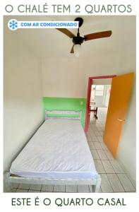 a bed in a room with a ceiling fan at Chalés Sununga Flats a 1 minuto da praia in Ubatuba