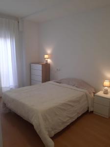 1 dormitorio con 1 cama con 2 mesitas de noche y 2 lámparas en Las Flores en Murcia