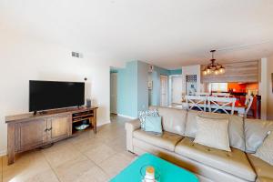 sala de estar con sofá y TV de pantalla plana en Emerald Isle 412, en Fort Walton Beach