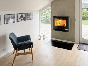 een woonkamer met een stoel en een tv bij Holiday home Græsted XI in Græsted