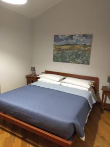 Montenero Val CocchiaraにあるLa casa di Pietraの壁に絵画が描かれたベッドルームのベッド1台