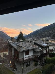 a house with a roof with mountains in the background at Le bonbon di morgex vda morgex cir 27 in Morgex