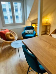 uma sala de estar com uma mesa de madeira e cadeiras em Le Rennais - Gare & centre ville em Rennes
