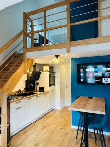 a kitchen with white cabinets and a blue wall at Le Rennais - Gare & centre ville in Rennes