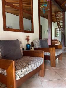 sala de estar con bancos de madera y mesa en CasaComVida pousada en Santo Antônio do Pinhal