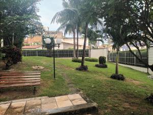 a park with a bench and palm trees at Dentro da praia in Fortaleza