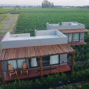 a house with a tub on top of a field at La Viñita Wine Lodge in San Carlos