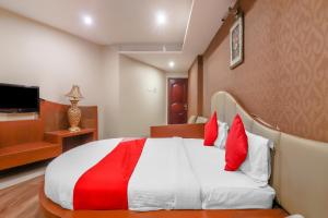 a bedroom with a bed with red and white pillows at Hotel O Grandeur By orbit Hotels Near Chennai shopping mall in Hyderabad