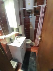 La salle de bains est pourvue d'un lavabo blanc et de toilettes. dans l'établissement Apartments Sonja, à Ohrid
