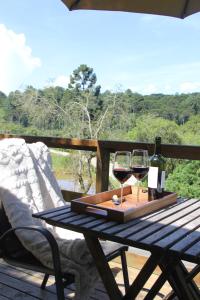 Cabana Rustica في كواترو باراس: طاولة مع كأسين من النبيذ على السطح