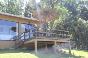 una terraza con sombrilla en la parte superior de una casa en Cabana Rustica, en Quatro Barras