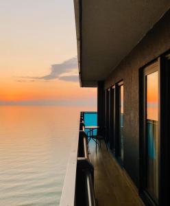 a building with a view of the ocean at sunset at Luxury PANORAMA sea view apartment & Central Batumi in Batumi