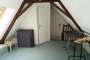 a attic room with a door and a table and chairs at La maison sur la place in Saint-André