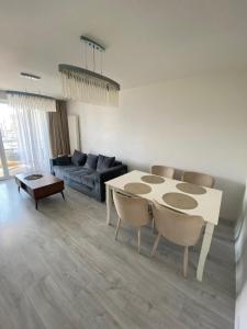 een woonkamer met een tafel en stoelen en een bank bij Royal Apartament in Braşov